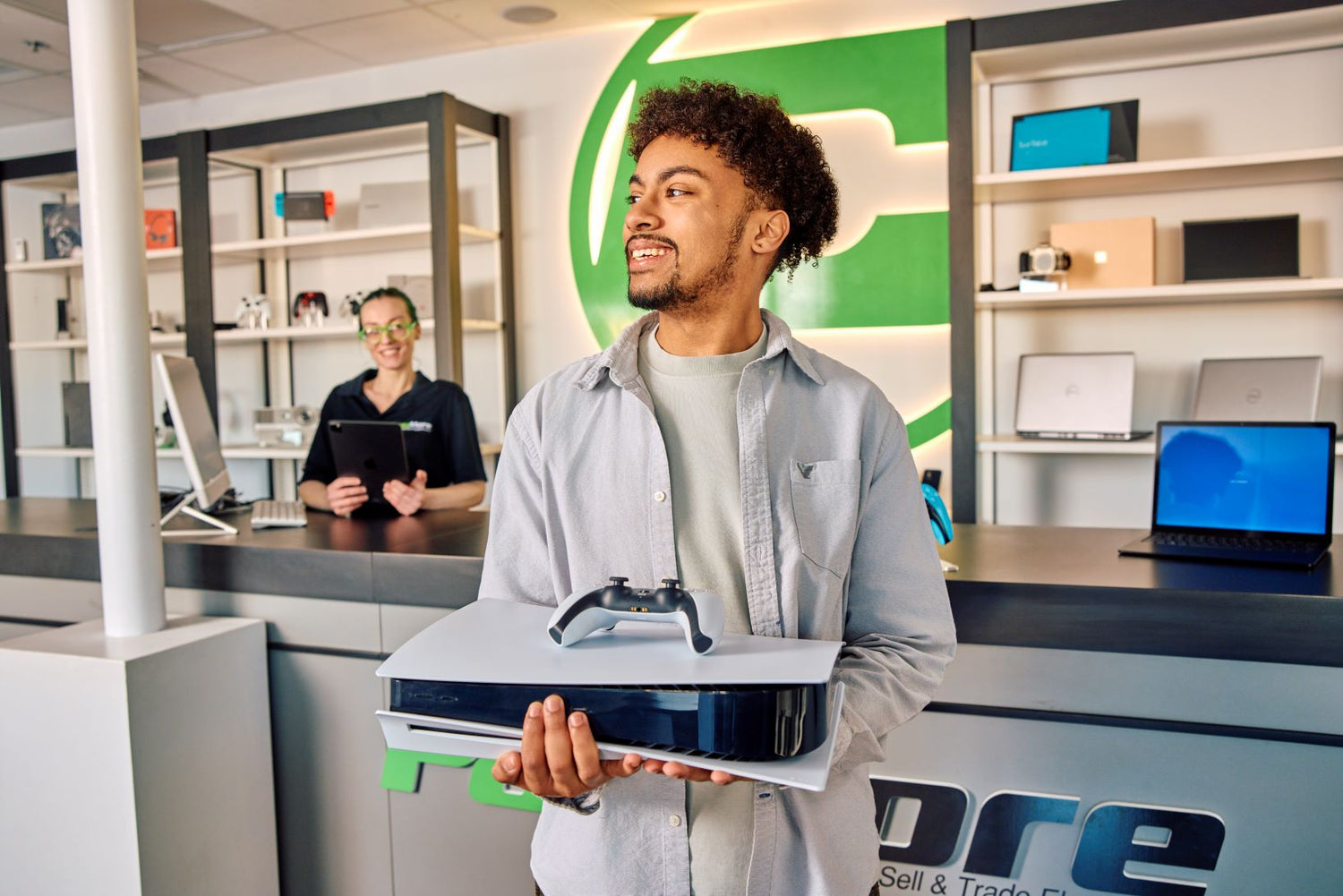 man purchasing a video game console and smiling